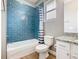 Bright bathroom features a tub with blue subway tile surround, shower curtain, and granite vanity top at 917 Shawna Shrs, Haines City, FL 33844