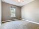 An empty bedroom with neutral walls, carpet, and a large window at 917 Shawna Shrs, Haines City, FL 33844