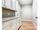 Bright laundry room features lots of white cabinets and granite countertops and wood-look tile floors at 917 Shawna Shrs, Haines City, FL 33844