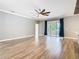 Spacious living room with wood-look floors, a ceiling fan, and a sliding glass door with view of the water at 917 Shawna Shrs, Haines City, FL 33844