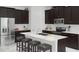 Modern kitchen featuring stainless steel appliances, an island with bar seating and dark wood cabinetry at 1919 Blissful Dr, Kissimmee, FL 34744
