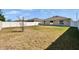 Fenced backyard features grass, a young tree and a partially visible home with a sliding glass door at 272 Pershing St, Bartow, FL 33830