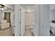 Neutral-toned bathroom featuring a toilet, shower with a curtain, and a door opening up to a bedroom with a chair at 272 Pershing St, Bartow, FL 33830