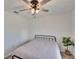 Simple bedroom with a metal bed frame, plush carpet, large window, and a modern ceiling fan at 272 Pershing St, Bartow, FL 33830