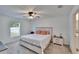Comfortable bedroom with a queen bed, ceiling fan, and views of the backyard through a bright window at 272 Pershing St, Bartow, FL 33830
