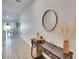 Bright hallway with a decorative mirror, leading to an open floor plan with the dining area and natural light at 272 Pershing St, Bartow, FL 33830
