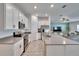 Well-lit kitchen featuring white cabinets, stainless steel appliances, and a center island with views of the living space at 272 Pershing St, Bartow, FL 33830