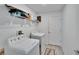 Well-lit laundry room with modern washer and dryer, utility sink, and shelving for storage at 272 Pershing St, Bartow, FL 33830