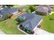Aerial view of home showing roof, surrounding landscaping and proximity to a community pond at 3518 Remington Oaks Way, Lakeland, FL 33810
