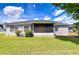 Backyard featuring a covered porch, mature landscaping, and a well-manicured lawn at 3518 Remington Oaks Way, Lakeland, FL 33810