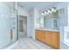 Spacious bathroom featuring double sinks, glass shower, soaking tub, and tiled floors at 3518 Remington Oaks Way, Lakeland, FL 33810