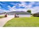 Single-story home featuring a well-maintained lawn and an attached two-car garage at 3518 Remington Oaks Way, Lakeland, FL 33810
