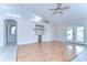 Bright living area with wood floors, built-in shelves, ceiling fan, and arched doorway at 3518 Remington Oaks Way, Lakeland, FL 33810