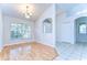 Open-concept living space featuring wood floors, arched doorways, and natural light at 3518 Remington Oaks Way, Lakeland, FL 33810