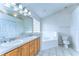 Bright bathroom featuring a double vanity, tile flooring, garden tub, and ample lighting at 3518 Remington Oaks Way, Lakeland, FL 33810