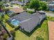 Aerial view of the home featuring a pool, screened in patio, and well-maintained backyard at 7402 Gunstock Dr, Lakeland, FL 33809