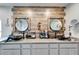 Bathroom showcasing a rustic wall, double sinks, and circular mirrors with black hardware at 7402 Gunstock Dr, Lakeland, FL 33809