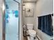 This bathroom features a walk-in shower with clear glass, toilet, and blue accents at 7402 Gunstock Dr, Lakeland, FL 33809