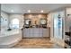 A spacious bathroom featuring dual sinks, and a separate tiled tub and glass shower at 7402 Gunstock Dr, Lakeland, FL 33809