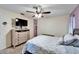 This bedroom features a ceiling fan, comfortable carpeting, and a wall-mounted television at 7402 Gunstock Dr, Lakeland, FL 33809