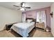 Bedroom boasts a ceiling fan, decorative curtains, and purple accent wall at 7402 Gunstock Dr, Lakeland, FL 33809