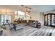 Open-concept living room featuring a large sectional couch and modern gray wood floors at 7402 Gunstock Dr, Lakeland, FL 33809