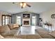 Comfortable living room with a cozy fireplace, large windows, and hardwood floors at 7402 Gunstock Dr, Lakeland, FL 33809
