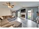 Spacious living room featuring a fireplace, vaulted ceilings, and modern gray wood floors at 7402 Gunstock Dr, Lakeland, FL 33809