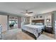 This main bedroom features a ceiling fan, carpet, and sliding doors leading to the lanai at 7402 Gunstock Dr, Lakeland, FL 33809