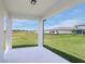 Covered back porch overlooking a spacious backyard with a view of the neighborhood at 8953 Wildlight Trl, Wildwood, FL 34785