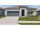 Charming one-story home with a well-manicured lawn, inviting entrance, and a two-car garage at 8953 Wildlight Trl, Wildwood, FL 34785