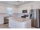 Modern kitchen featuring stainless steel appliances, a center island, and white cabinets at 8953 Wildlight Trl, Wildwood, FL 34785