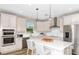 Well-lit kitchen featuring stainless steel appliances, a spacious island, and pendant lighting at 8953 Wildlight Trl, Wildwood, FL 34785