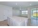 Bright kitchen area with an island opens to living space and a sliding glass door to the patio at 8953 Wildlight Trl, Wildwood, FL 34785