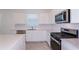 Bright kitchen boasts white cabinets, stainless steel appliances, and quartz countertops at 8953 Wildlight Trl, Wildwood, FL 34785
