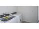 Convenient laundry room featuring a Whirlpool washer and dryer, with overhead shelving for supplies at 8953 Wildlight Trl, Wildwood, FL 34785