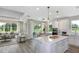 Bright and open living area flowing into a modern kitchen with island seating and outdoor access at 8953 Wildlight Trl, Wildwood, FL 34785