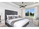 Calming main bedroom with shiplap wall, tufted headboard, and bright natural light at 8953 Wildlight Trl, Wildwood, FL 34785