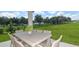 Outdoor patio with a wicker dining set, overlooking a green lawn and wooded area at 8953 Wildlight Trl, Wildwood, FL 34785