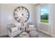 Inviting sitting room featuring two chairs, an over-sized decorative clock, and large window with lots of light at 8953 Wildlight Trl, Wildwood, FL 34785