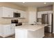 Modern kitchen featuring white cabinetry, stainless steel appliances, an island, and quartz countertops at 1768 Frogmore Ave, Haines City, FL 33844