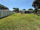 Backyard featuring a large grassy area, partial fence, and view of neighboring houses in a residential setting at 231 Connie Lee Ct, Lakeland, FL 33809