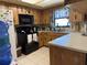 Functional kitchen with wooden cabinets, black appliances, and neutral countertops at 231 Connie Lee Ct, Lakeland, FL 33809