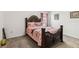 Cozy bedroom featuring a carved dark wood headboard, neutral carpet, and a decorative bedspread at 356 Loch Ct, Davenport, FL 33837