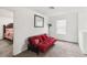 Bonus room area with red futon, mirror and carpet flooring at 356 Loch Ct, Davenport, FL 33837