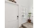 Inviting foyer with neutral-toned stairs, a white front door, and a decorative plant at 356 Loch Ct, Davenport, FL 33837