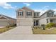 Inviting two-story home featuring a well-manicured lawn, neutral siding, and a two-car garage at 356 Loch Ct, Davenport, FL 33837