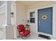 Charming front porch with a red chair and a blue door adorned with a sunflower wreath at 356 Loch Ct, Davenport, FL 33837