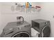Laundry room with gray Whirlpool washer and dryer, and white wire shelving at 356 Loch Ct, Davenport, FL 33837