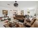 Open-concept living room with a brown sofa, a glass coffee table, and views of the dining and kitchen areas at 356 Loch Ct, Davenport, FL 33837